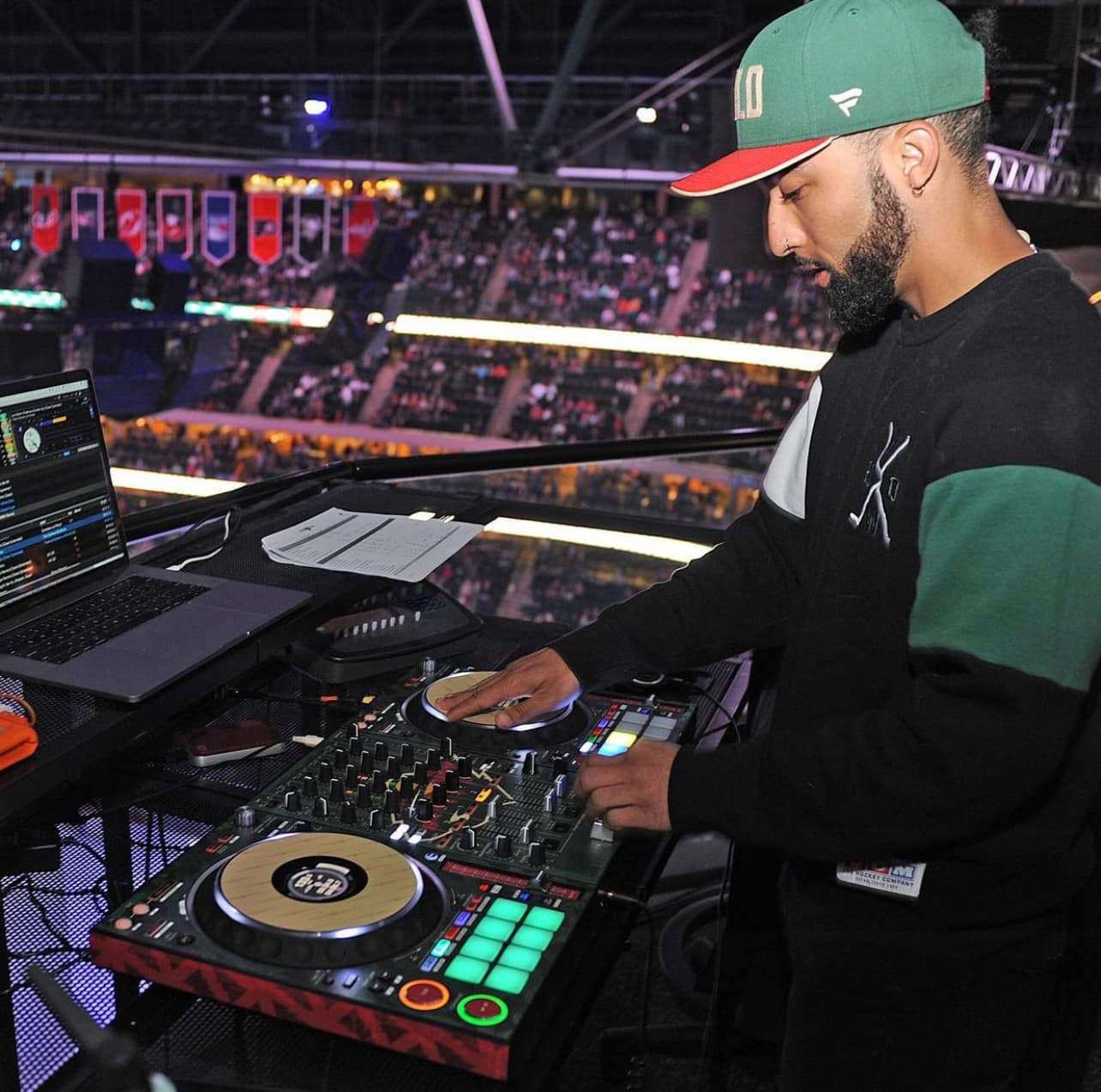 DJ YS mixing on the decks in a packed arena